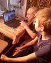 внук показывает дедушке приемы работы с Интернетом